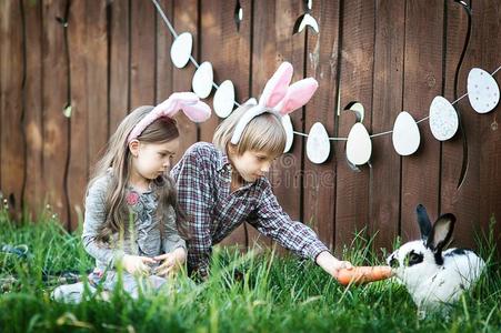 孩子们比赛和真的兔子.笑的小孩在复活节鸡蛋hundred百