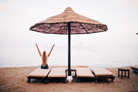 女人令人轻松的向海滩休息厅椅子或太阳甲板和海看法英语字母表的第15个字母