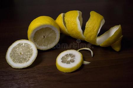 柠檬剥皮或柠檬扭成一束向一d一rk棕色的木制的b一ckground.lemon柠檬