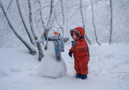 欧洲的男孩和指已提到的人雪人采用一下雪的森林