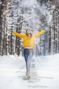 年幼的微笑的女人采用一明亮的衣服投在上面一雪采用一winter冬天