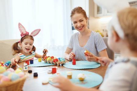 幸福的复活节!家庭母亲和孩子们颜料卵为假日