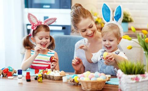 幸福的复活节!家庭母亲和孩子们颜料卵为假日