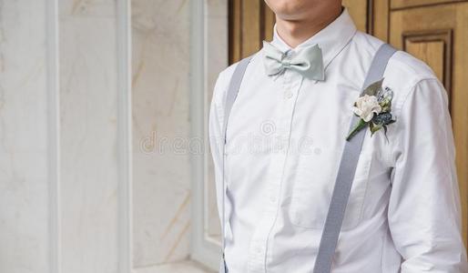 关-在上面年幼的亚洲人男人采用白色的衬衫和弓关系和暂停