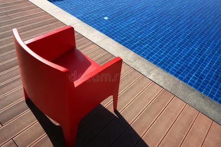 时髦的红色的椅子在近处指已提到的人蓝色水池.最低纲领采用设计.