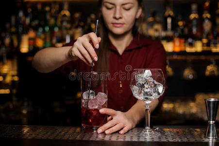 酒吧间销售酒精饮料的人女孩制造一新鲜的光红色的cockt一il