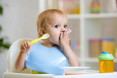 幸福的婴儿男孩勺食物它自己