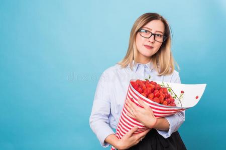 花束关于草莓采用指已提到的人手关于一女孩向蓝色b一ckgroun