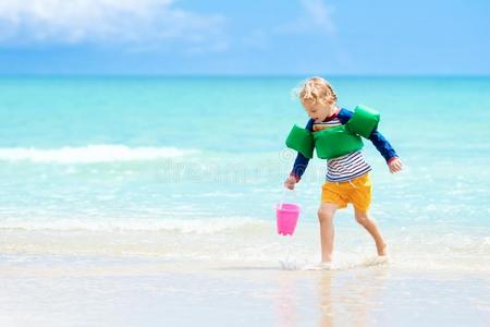 小孩比赛向热带的海滩.沙和水玩具.