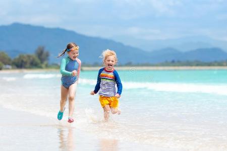 小孩向热带的海滩.孩子们演奏在海.