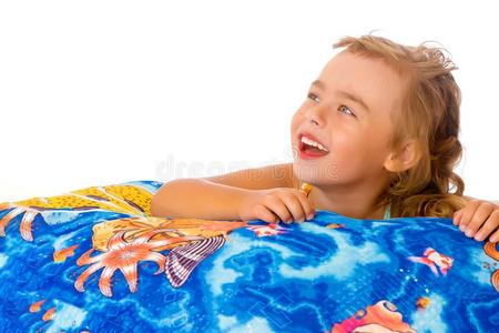 小的女孩采用一游泳衣是（be的三单形式sitt采用g向一枕头.