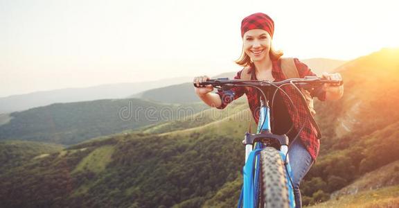 女人旅行者向一自行车一t顶关于mount一in一t日落在户外