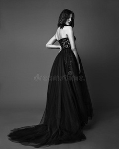时尚工作室照片关于埃甘特女人采用长的黑的衣服.黑的
