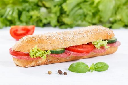潜水艇三明治全部的谷物谷物s法国长面包和意大利腊肠火腿向木材