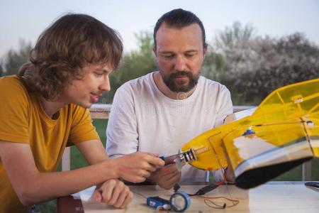 儿子和父亲使home使无线电-受约束的模型飞机Anguilla安格拉