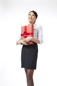 棚拍年轻商务女士抱着礼物盒