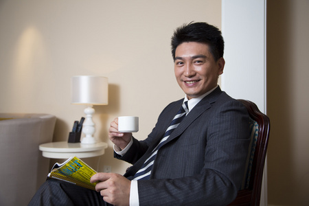 中年商务男士在书房喝咖啡看杂志