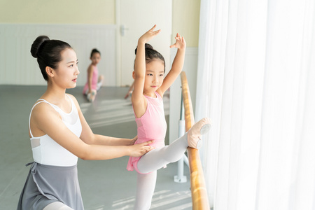 年轻舞蹈老师教小女孩们跳芭蕾