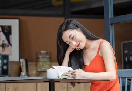 年轻女子看咖啡店看书