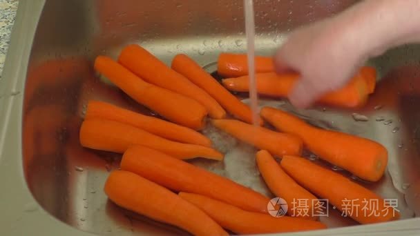 女人洗胡萝卜在厨房的水槽视频
