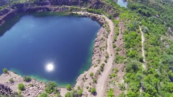 在与太阳反射的坑湖上空飞行视频