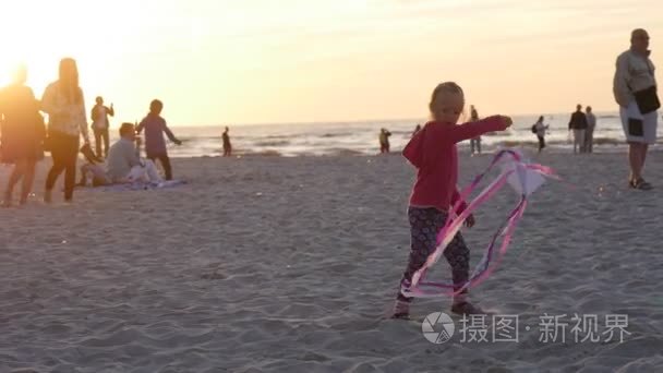 摇曳的小风筝女孩女孩苍蝇人家庭剪影正走在海滩上孩子们玩国际风筝节莱波兰