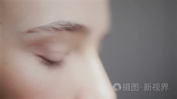 Side view of young beautiful woman looking at camera. Close-up