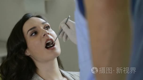牙医检查牙齿的一名年轻女子视频
