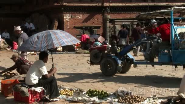 男人坐在一把伞在市场下视频