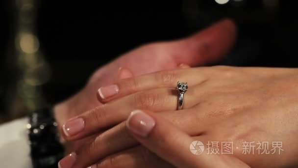 男人抱着双手的手指上戴的钻石订婚戒指的女人。浪漫