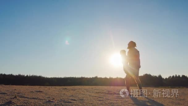 强抛出的父子在天空中。在日落时跟他一起玩