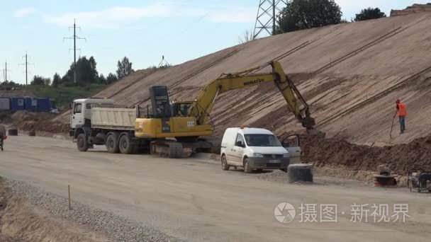 挖掘机挖沙子和滚子机调配新公路层