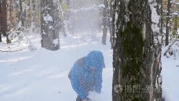 孩子在玩投掷雪球从树在冬季公园后面视频