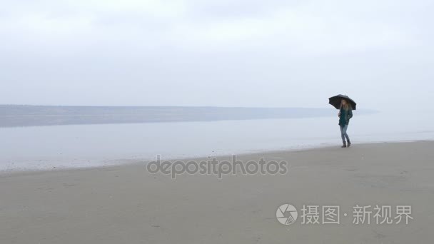 女孩与伞向走在沙滩上从左到右视频