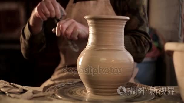 其他设备在桌上，粘土陶工手传统的瓷器上的图案设计的凿子与模糊的特写