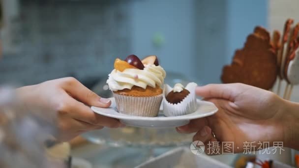 彩色指甲的糕点女孩发送小的白手板, 有两个美味的蛋糕。一种是棕色，另用黄油奶油和水果片装饰视频