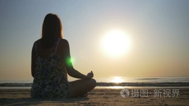 冥想在朝大海沙滩上的女人视频