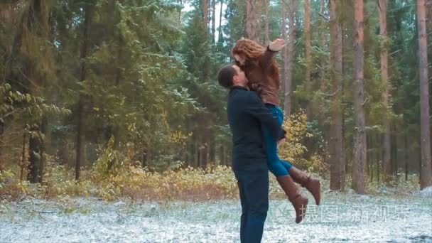 娱乐的年轻夫妇在冬季森林