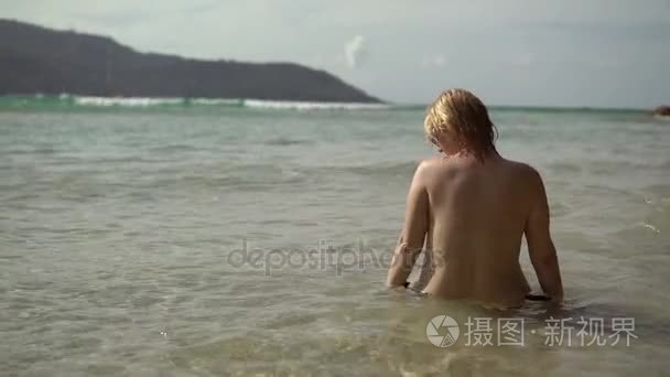 年轻性感的女人在海边晒日光浴视频