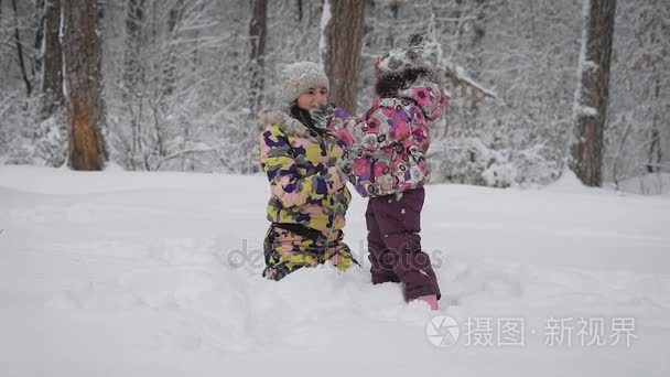 带着女儿在树林里的女孩。母亲与女儿在散步。布鲁内特纠正孩子夹克婴儿还没生病，可以继续冬季娱乐视频