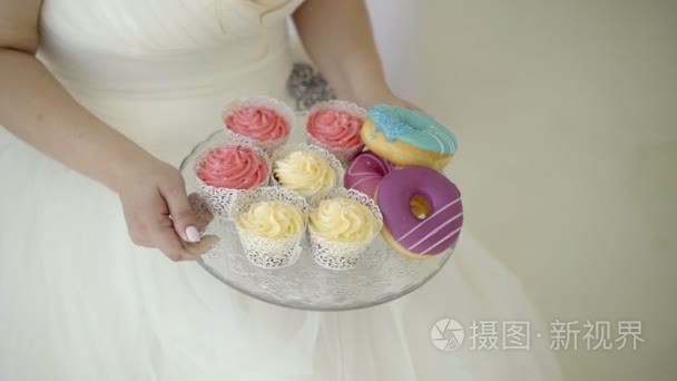 结婚礼服的年轻女子带板的糖果视频