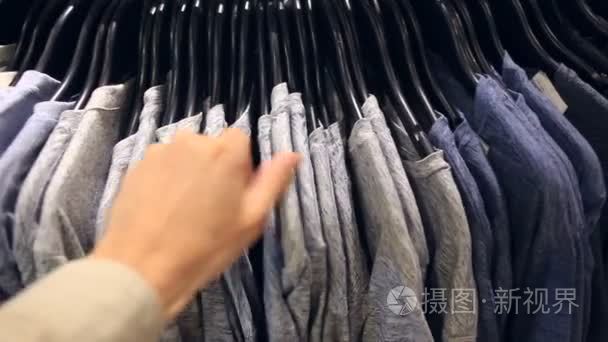 一个人选择的衣服为自己在一家服装店视频