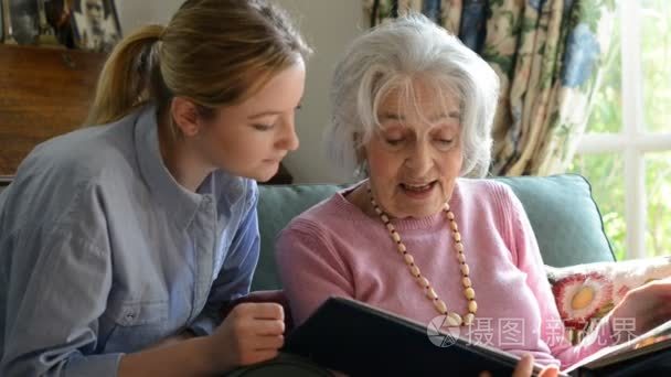 奶奶看着相册与成人的孙女