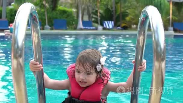 小女孩在漂浮在游泳池游泳背心视频