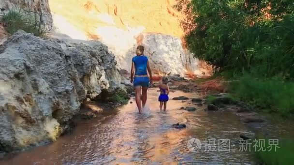 母亲和女儿在玩赤脚在溪水视频