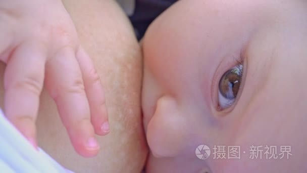 女子母乳喂养她的孩子户外活动