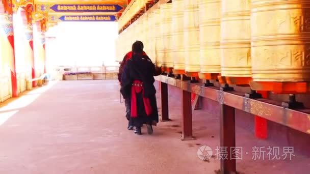 藏族僧人和尼姑走和祈祷轮子在四川 Yarchen 噶尔寺