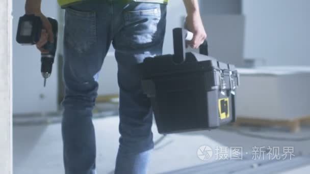 建筑工人晚上走在里面，建筑和携带工具箱视频