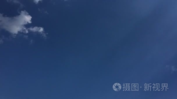 白云在蔚蓝的天空消失在烈日下。时移运动云朵蓝色天空背景。蓝蓝的天空。云。蓝天与白云