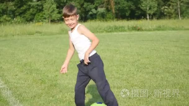 在足球场踢足球的男孩视频